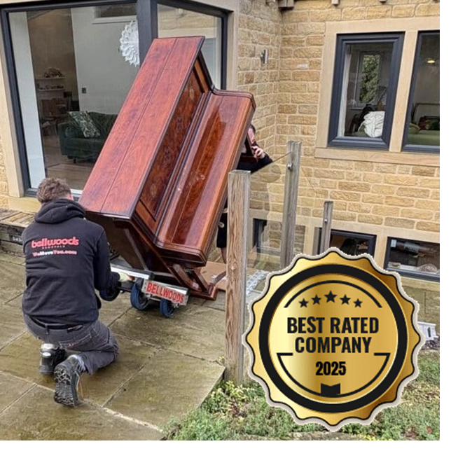 White Glove Removals specialist carefully moving an upright piano on skates across a Yorkshire patio